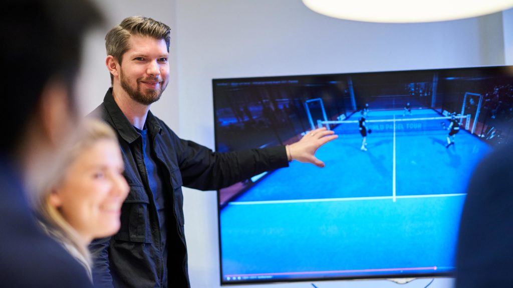 Jimmy Lindström står framför en skärm och förklarar hur Padelplay fungerar.